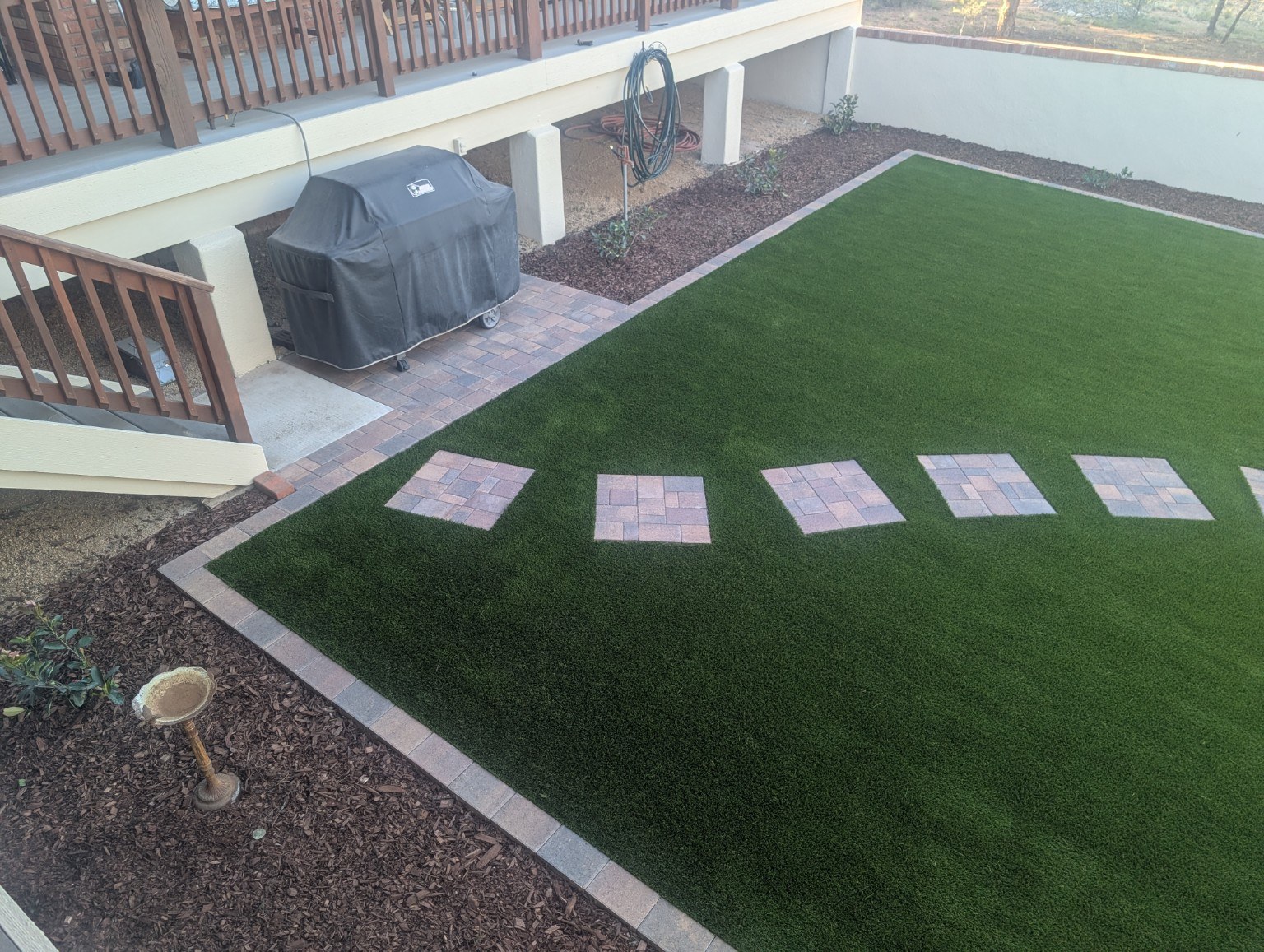 Artificial turf lawn with paver stepping pads and border
