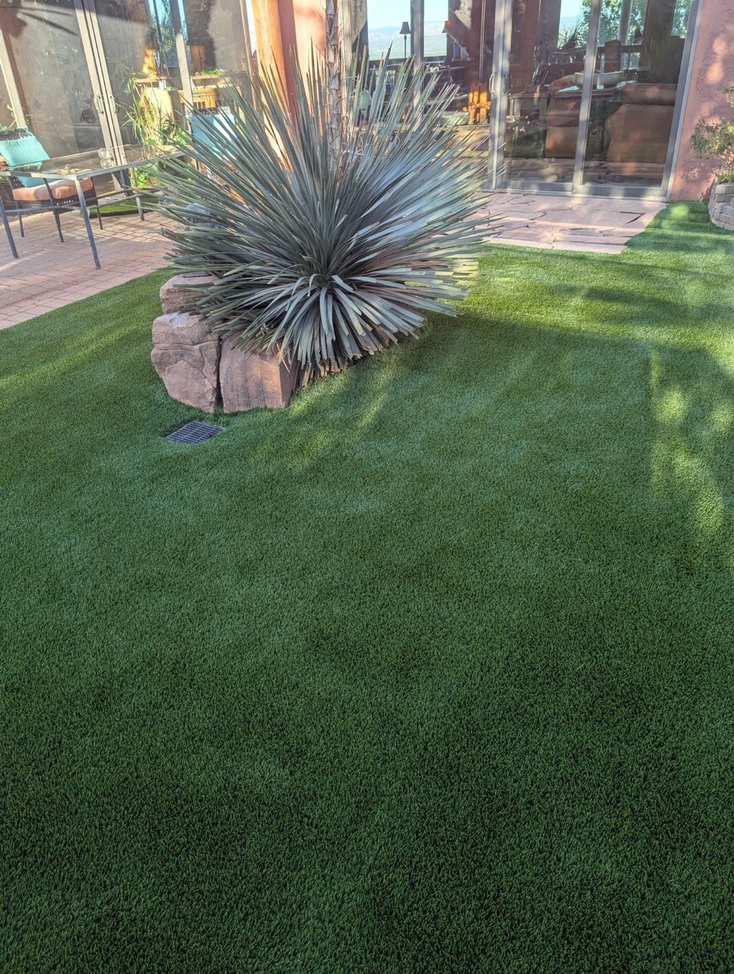 Artificial turf with desert landscaping and boulders